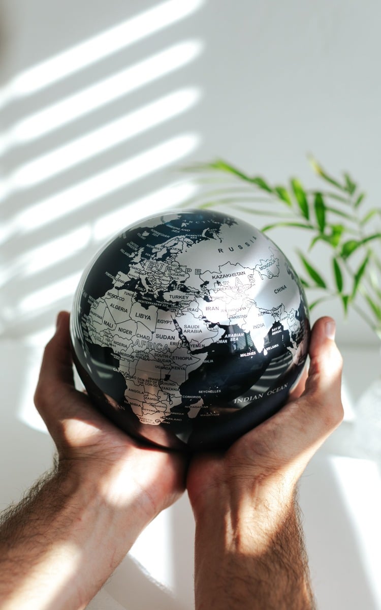 Black and silver globe held in hands